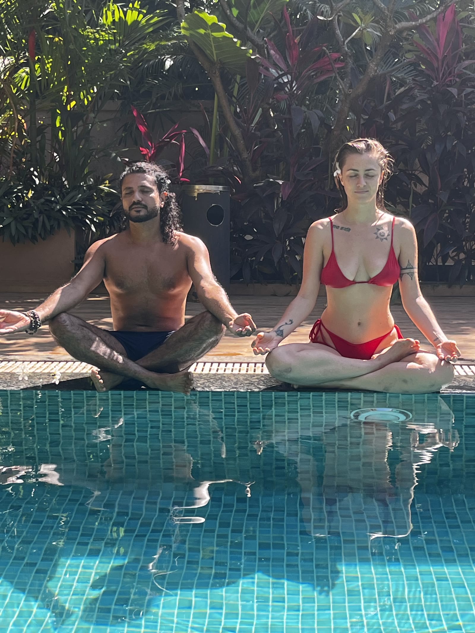 Two people seated by the pool in a retreat meditation practice